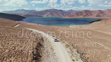 在4x4路的高空，汽车沿着砾石小径驶向干旱山区的湖泊。 帕米尔公路<strong>丝绸之路</strong>